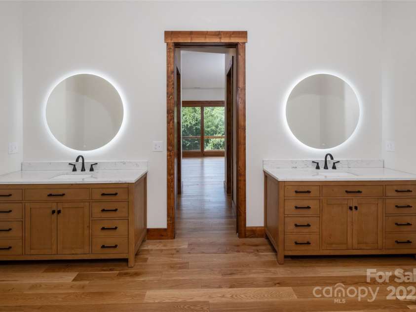 750 Silver Springs Drive, Banner Elk, NC 28604.  MLS# CAR4160928, YatesRealty ID 553. Main floor primary suite with incredible mountain views, access to porch & 2 walk-in closets. Primary bathroom with double vanities & backlit mirrors, soaking bathtub, shower & water closet.