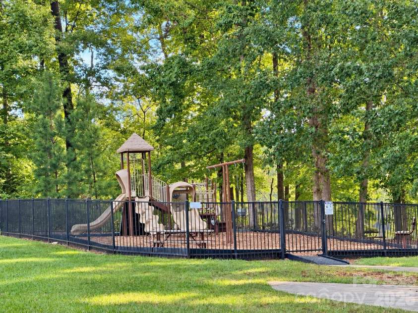 8149 Merryvale Lane, Charlotte, NC 28214.  MLS# CAR4432571, YatesRealty ID 55655. Community playground surrounded by lush trees.