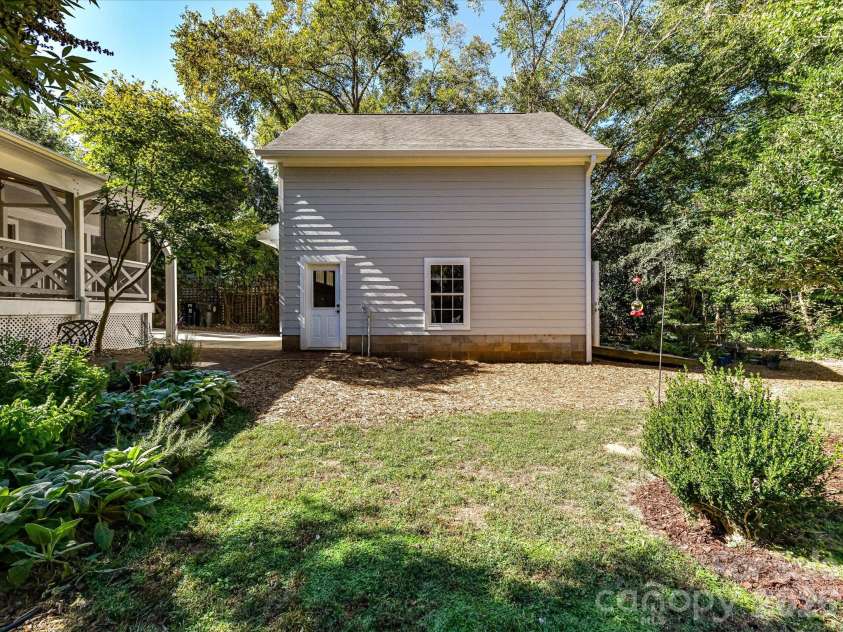10709 Danesway Lane, Cornelius, NC 28031.  MLS# CAR4431451, YatesRealty ID 55685. The spacious detached two-car garage offers ample room for parking and storage, surrounded by mature trees and lush landscaping in a peaceful, private setting.
