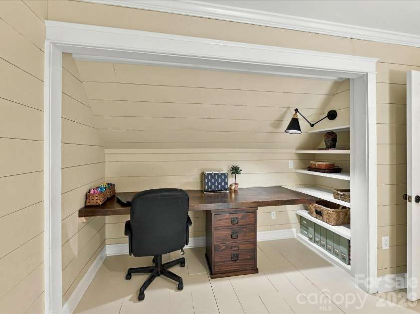 10709 Danesway Lane, Cornelius, NC 28031.  MLS# CAR4431451, YatesRealty ID 55685. This charming flex space features a custom built-in desk with rich wood countertops, open shelving for ample storage, shiplap walls, and dedicated task lighting, creating an ideal home office or study nook.