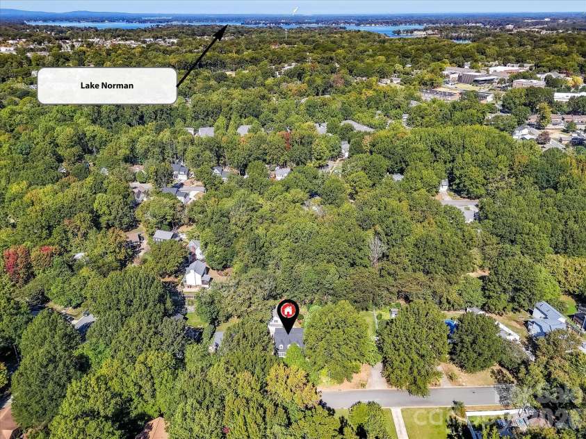 10709 Danesway Lane, Cornelius, NC 28031.  MLS# CAR4431451, YatesRealty ID 55685. This stunning aerial view highlights the home's peaceful, tree-lined setting and convenient proximity to beautiful Lake Norman, offering easy access to the area's waterfront recreation, shopping, and dining.