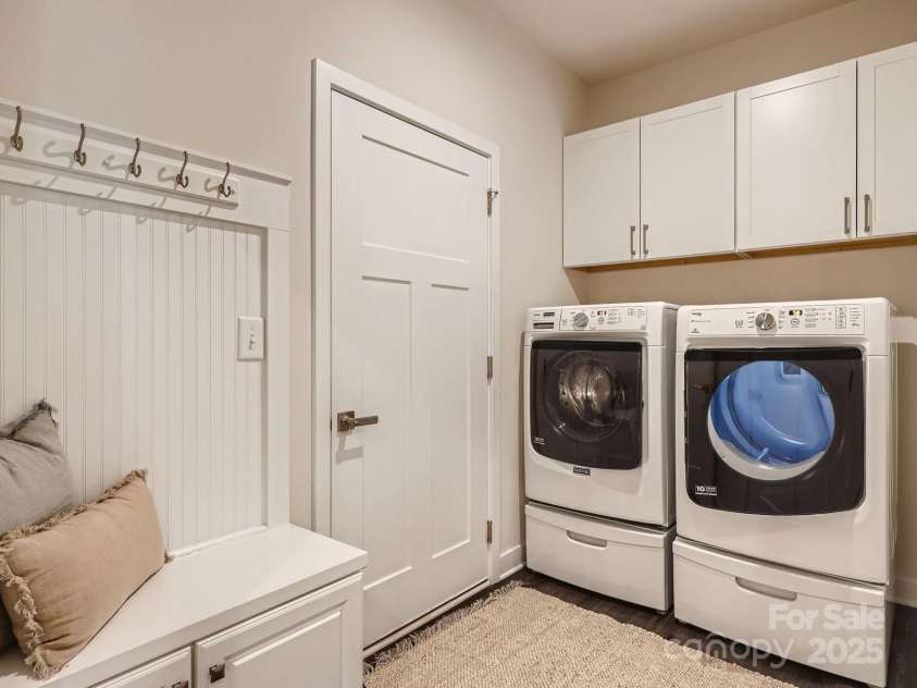 125 Lanyard Drive, Mooresville, NC 28117.  MLS# CAR4234396, YatesRealty ID 5571. Large Laundry Room has upper cabinetry for storage and a built in drop zone bench storage beadboard detail and hanging hooks.