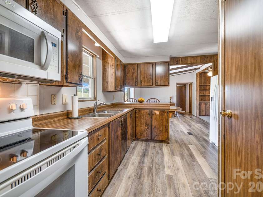 67 & 69 Allman Hill Road, Weaverville, NC 28787.  MLS# CAR4427443, YatesRealty ID 55771. Kitchen. Dining area past bar.