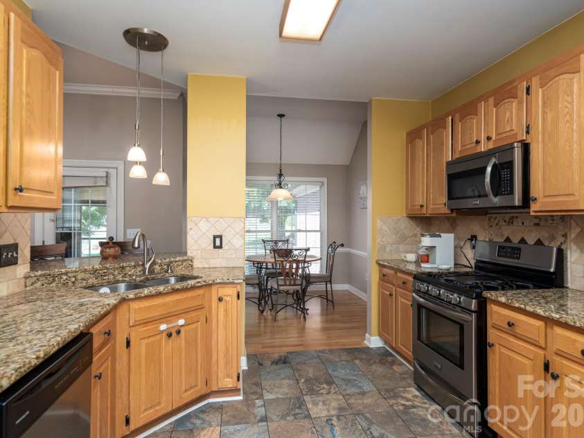 2915 Woodfield Lane, Lincolnton, NC 28092.  MLS# CAR4432025, YatesRealty ID 55823. Kitchen with granite counters and tiled splash