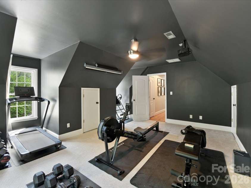 17127 Windy Oaks Court, Cornelius, NC 28031.  MLS# CAR4432499, YatesRealty ID 55826. This spacious Bonus Room features dramatic charcoal walls, angled ceilings, plush carpeting, abundant natural light, and a versatile layout ideal for a home gym, media room, recreation area, or additional flex space