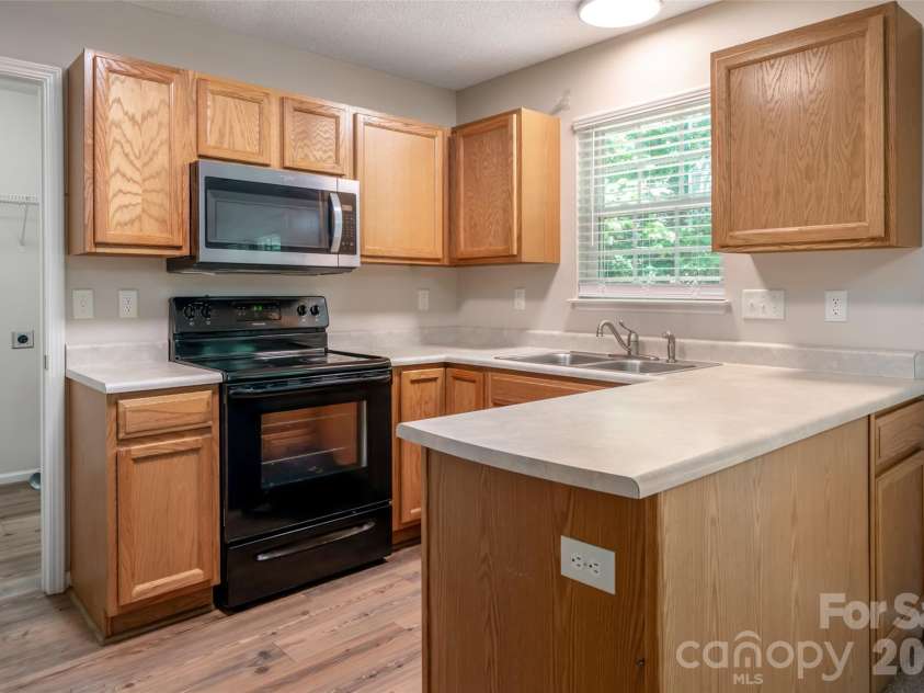 201 Birch Lane, Arden, NC 28704.  MLS# CAR4386730, YatesRealty ID 56230. Kitchen featuring stove/oven, fridge, dishwasher and microwave.