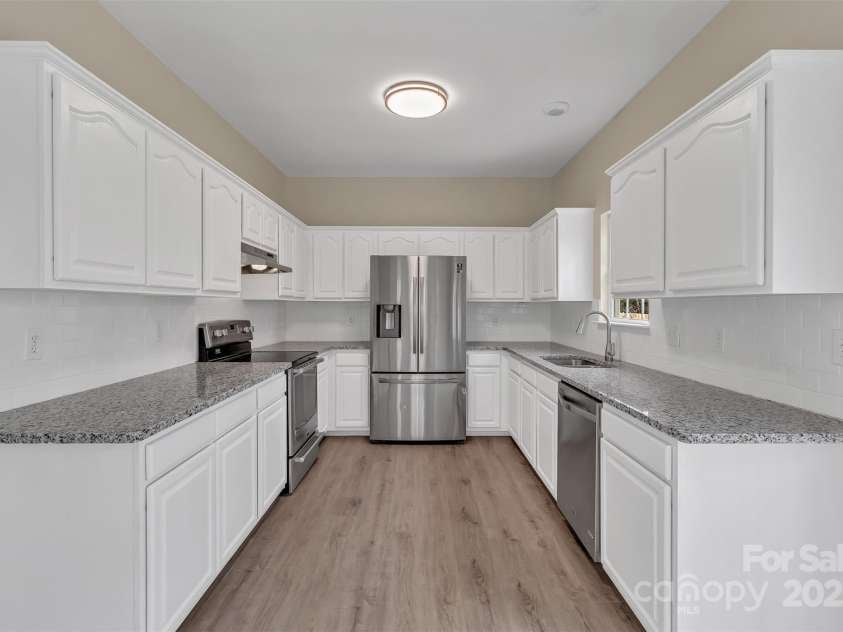 1331 Copper Creek Lane, Fort Mill, SC 29715.  MLS# CAR4326414, YatesRealty ID 5626. Freshly painted white kitchen cabinets and beautiful granite countertops bring life and beauty to this kitchen! Stainless steel appliances and new hood, new lighting fixtures and new garbage disposal! Fridge does con