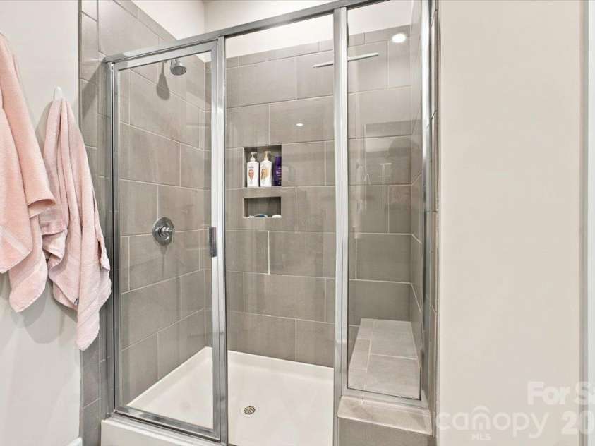 7722 Porrera Street, Charlotte, NC 28214.  MLS# CAR4434037, YatesRealty ID 56499. Primary tile shower features a bench for relaxing.