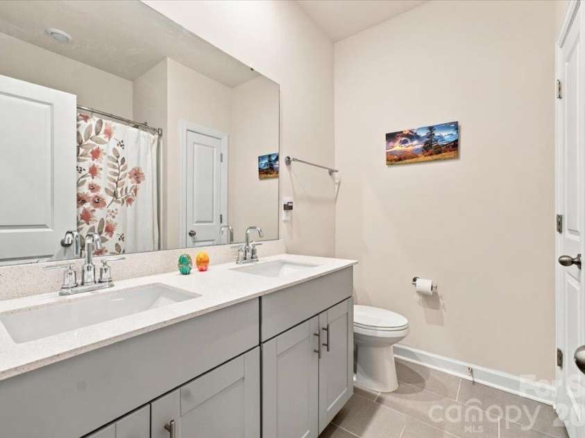 7722 Porrera Street, Charlotte, NC 28214.  MLS# CAR4434037, YatesRealty ID 56499. Shared bath with a dual sink vanity & storage.