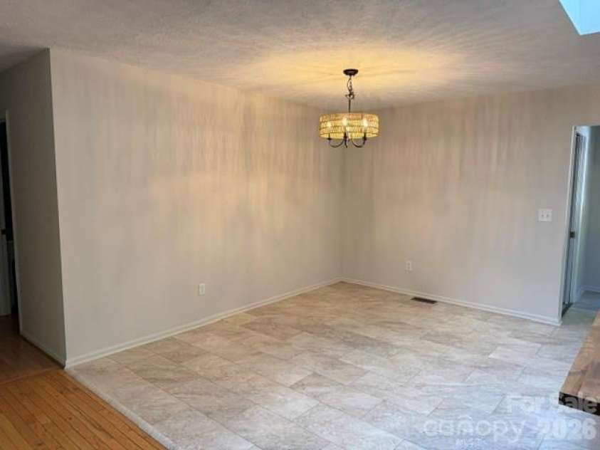 177 Natural Trail, Sylva, NC 28779.  MLS# CAR4434524, YatesRealty ID 56632. Dining area, lighting from the rattan chandelier reflects shadows on wall