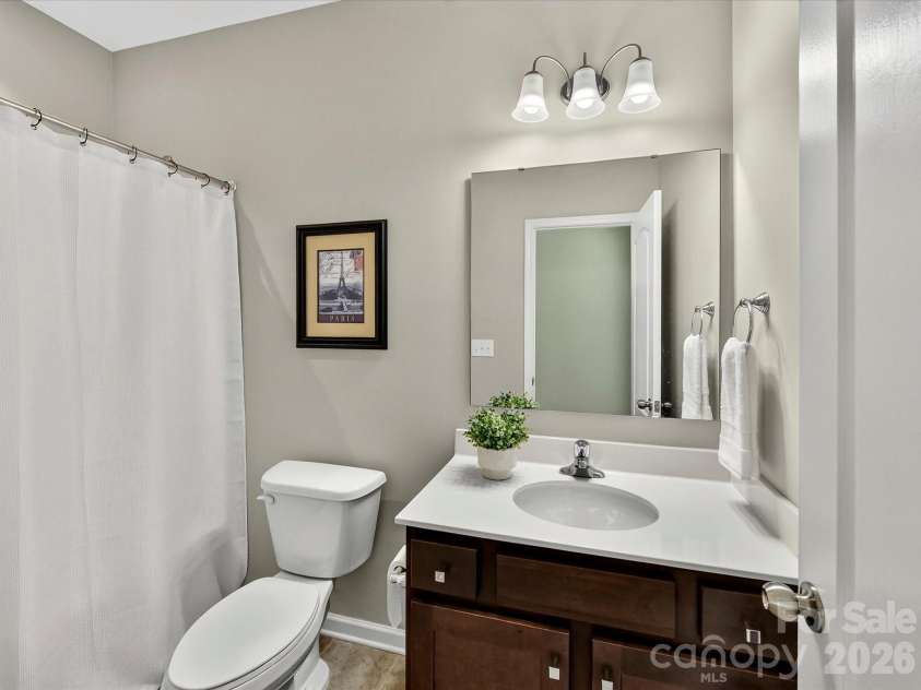 12613 Longford Crossing Place, Huntersville, NC 28078.  MLS# CAR4395393, YatesRealty ID 5708. The private ensuite bath features a spacious vanity with ample storage, a tub/shower combination, and convenient direct access from the bedroom, providing comfort and functionality for guests or family memb