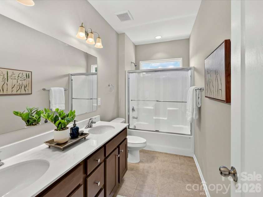 12613 Longford Crossing Place, Huntersville, NC 28078.  MLS# CAR4395393, YatesRealty ID 5708. This well-appointed full bath features a dual-sink vanity, ample counter space, and a tub/shower combination, offering both comfort and convenience for family and guests.