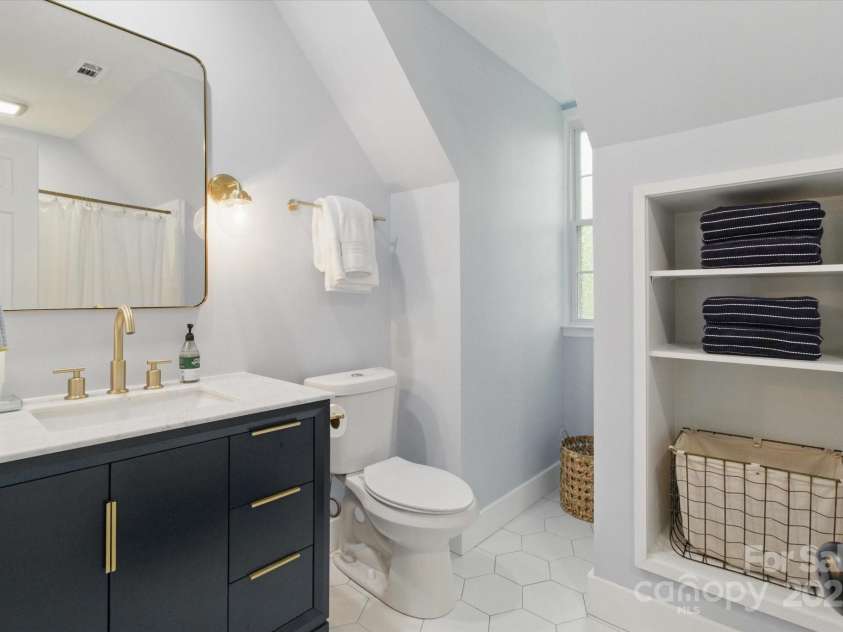 7514 Pewter Lane, Charlotte, NC 28270.  MLS# CAR4244658, YatesRealty ID 5718. The newly updated full bathroom has modern tile and fixtures with extra storage.