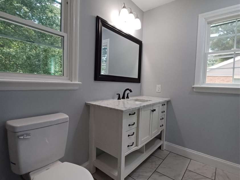 5717 Ruth Drive, Charlotte, NC 28215.  MLS# CAR4435760, YatesRealty ID 57388. Primary Bath with updated sink base cabinet, flooring, mirrow, and lighting