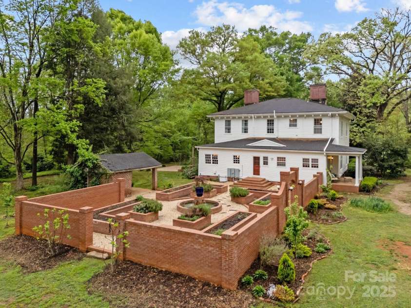 740 Woodlawn Avenue, Mount Holly, NC 28120.  MLS# CAR4244621, YatesRealty ID 5739. All of the brickwork and formal raised bed gardens (and fish pond) were added by the current owners. There are many perennials that should return!