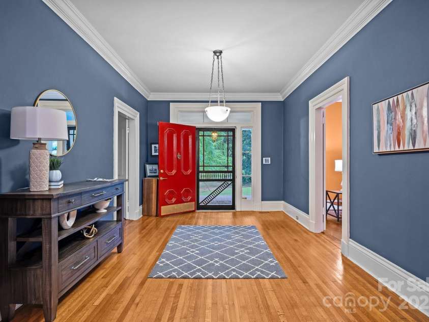 740 Woodlawn Avenue, Mount Holly, NC 28120.  MLS# CAR4244621, YatesRealty ID 5739. The front foyer is massive and flanked on either side by large rooms with fireplaces.  The room to the right in this picture is the formal living room.  The room to the left is the downstairs bedroom with half bath.