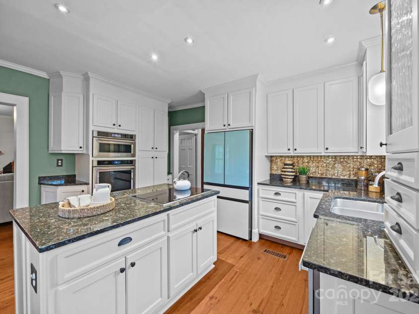 740 Woodlawn Avenue, Mount Holly, NC 28120.  MLS# CAR4244621, YatesRealty ID 5739. The kitchen features a Wolf electric cooktop, Miele dishwasher, and Kitchen-Aid wall oven and microwave.