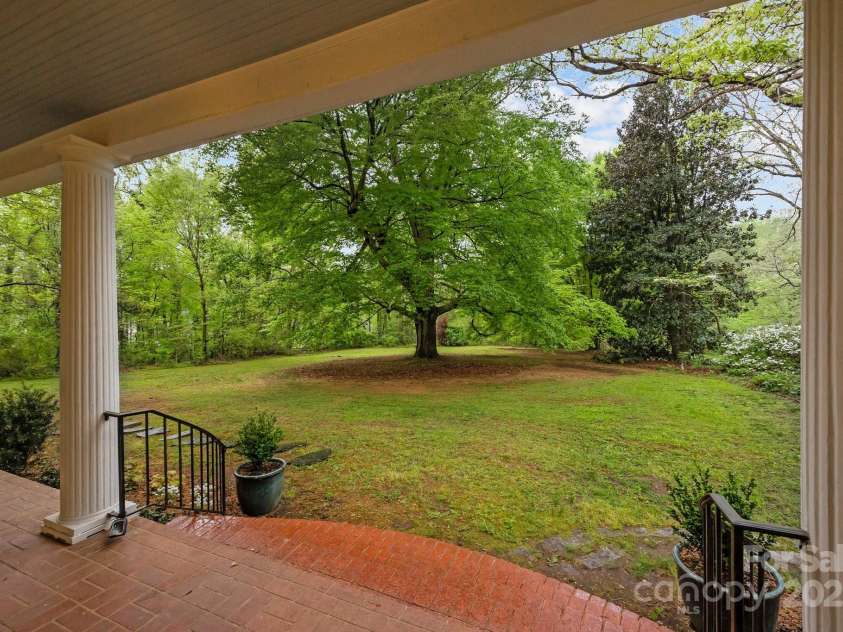 740 Woodlawn Avenue, Mount Holly, NC 28120.  MLS# CAR4244621, YatesRealty ID 5739. View of the front yard from the front porch.  The beech tree is thought to have been planted in 1857 and has carvings of names and initials from over a century ago.