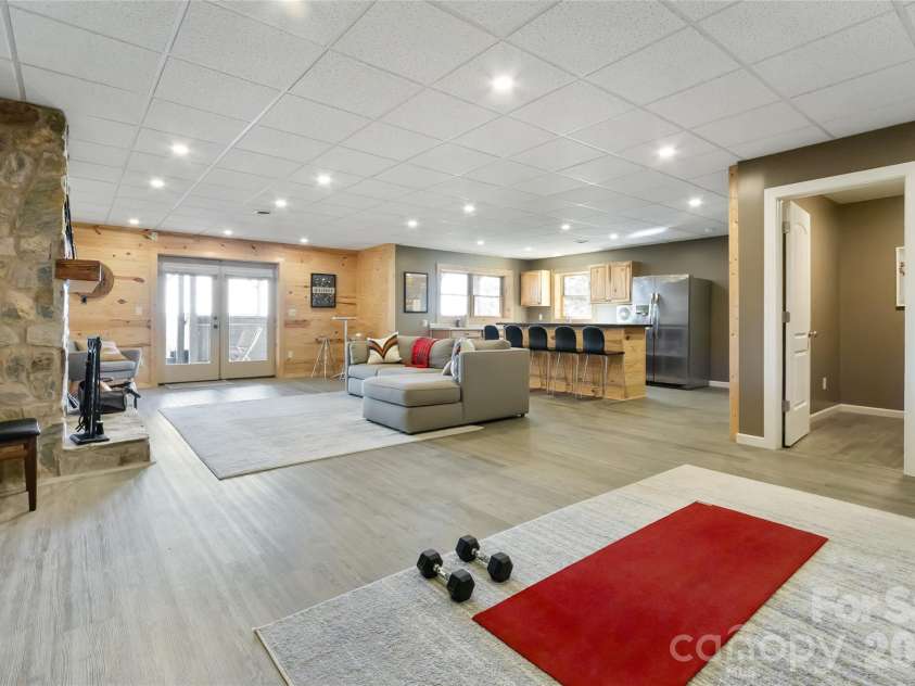 656 Arbra Mountain Way, Bostic, NC 28018.  MLS# CAR4432253, YatesRealty ID 57598. Lower Level - Living room with wood fireplace, kitchenette, bathroom