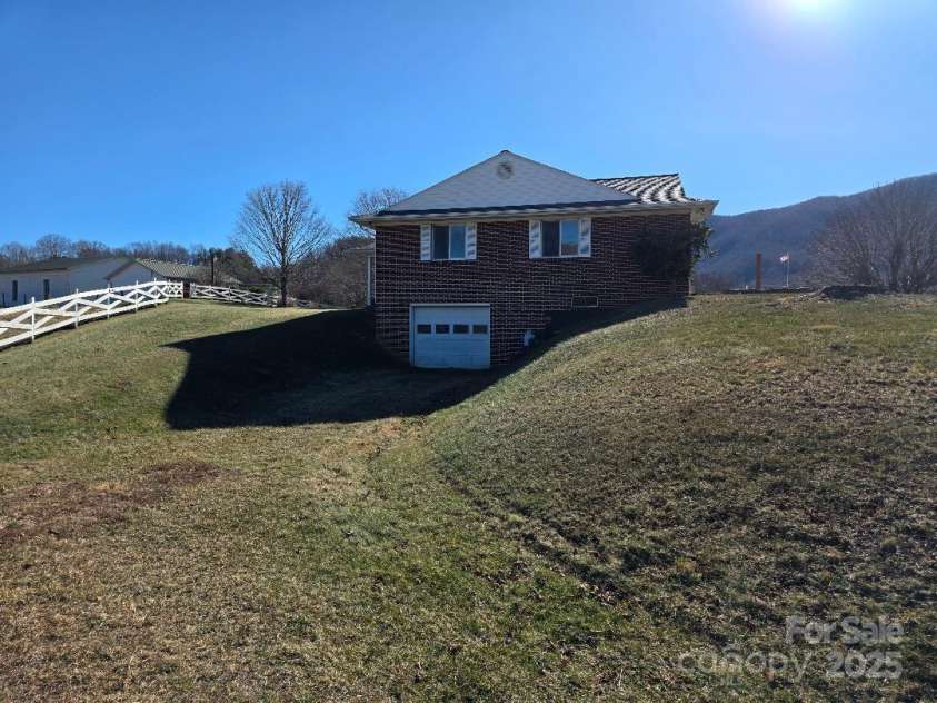 1375 US Highway 19E Highway, Burnsville, NC 28714.  MLS# CAR4329254, YatesRealty ID 576. View of north side of house and drive-in basement
