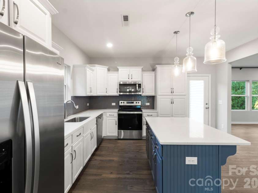 1023 Freeman View Drive, Albemarle, NC 28001.  MLS# CAR4429670, YatesRealty ID 57682. Many kitchen upgrades include stainless Whirlpool appliances, cabinets/w quartz solid surface counter tops, full backsplash, pendant light fixtures and island.