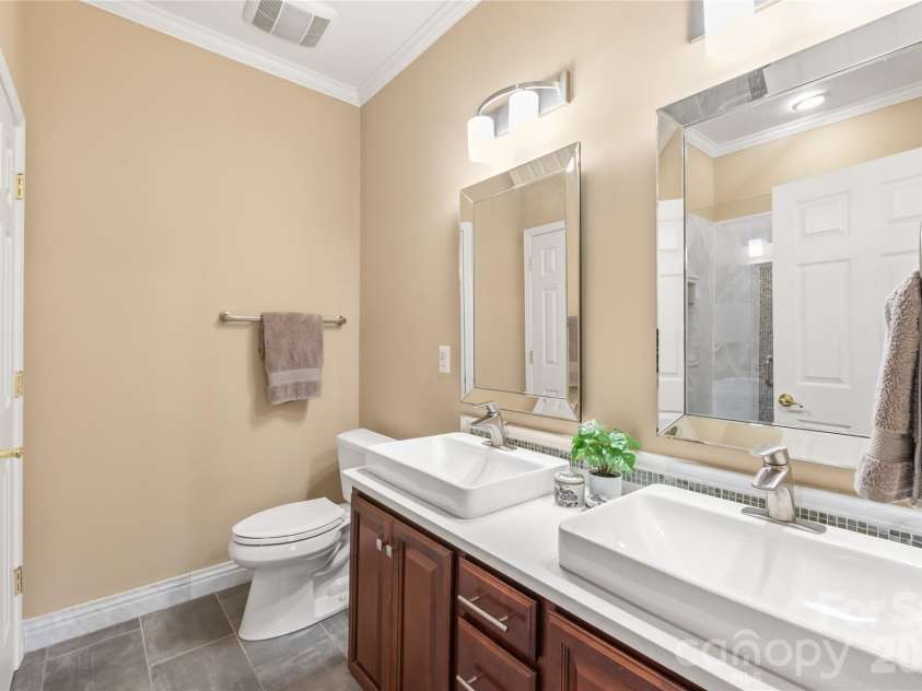 4780 Grier Farm Lane, Charlotte, NC 28270.  MLS# CAR4433351, YatesRealty ID 57760. Outfitted with crisp tile flooring, an updated vanity with ample storage, and rich quartz surfaces, this refreshed primary bath blends style with everyday functionality.