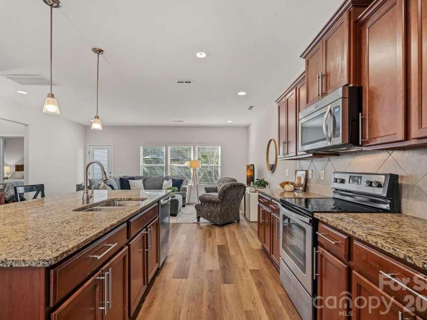 13326 Pierre Reverdy Drive, Davidson, NC 28036.  MLS# CAR4435596, YatesRealty ID 57935. Granite counters and handsome wood cabinets