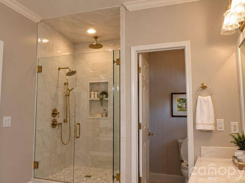 5480 Glen Forest Drive, Charlotte, NC 28226.  MLS# CAR4420356, YatesRealty ID 57976. Digitally Designed Primary Shower remodel idea: frameless shower doors, a second shower head and a wall storage cut-out.