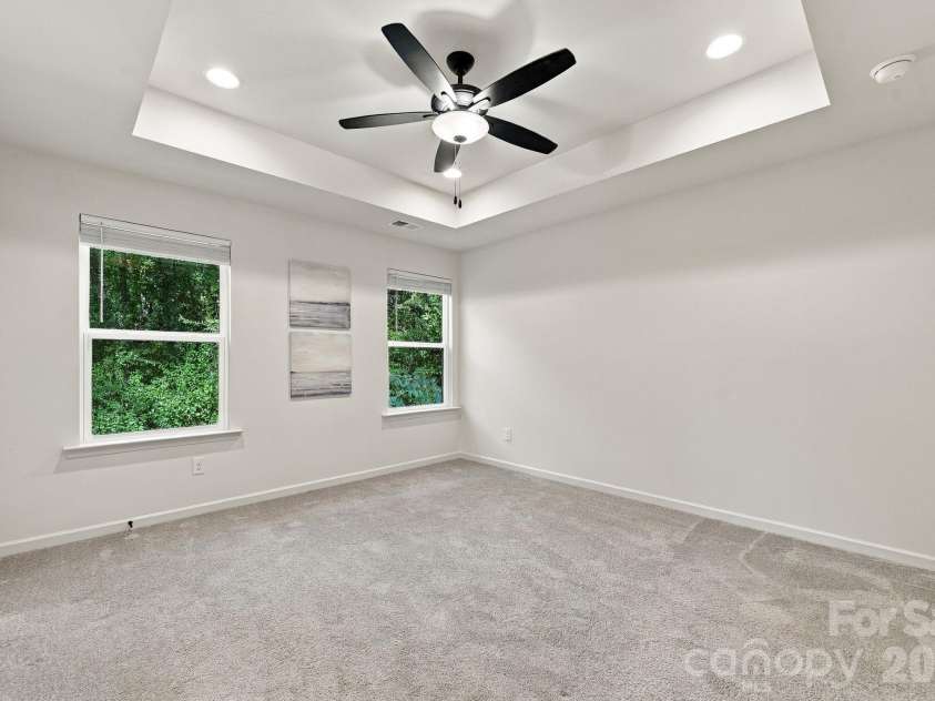 4715 Crestmont Drive, Charlotte, NC 28205.  MLS# CAR4436619, YatesRealty ID 58001. Primary bedroom with tray ceiling overlooks tree-lined yard for privacy