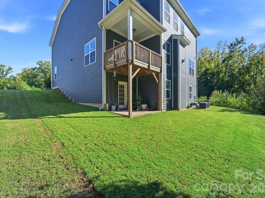 4603 Monument Valley Drive, Indian Land, SC 29707.  MLS# CAR4433542, YatesRealty ID 58574. Side and Backyard showing patio and balcony/deck