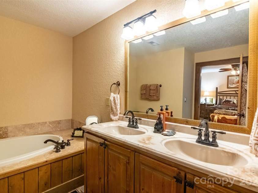 620 Sapphire Valley Road, Cashiers, NC 28717.  MLS# CAR4329121, YatesRealty ID 598. En-Suite #1 Bathroom with double sink vanity and jet tub.