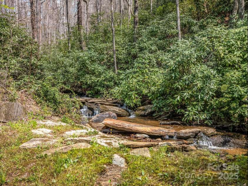 560 Charleys Knob Road, Pisgah Forest, NC 28768.  MLS# CAR4246535, YatesRealty ID 6002. Backyard waterfall