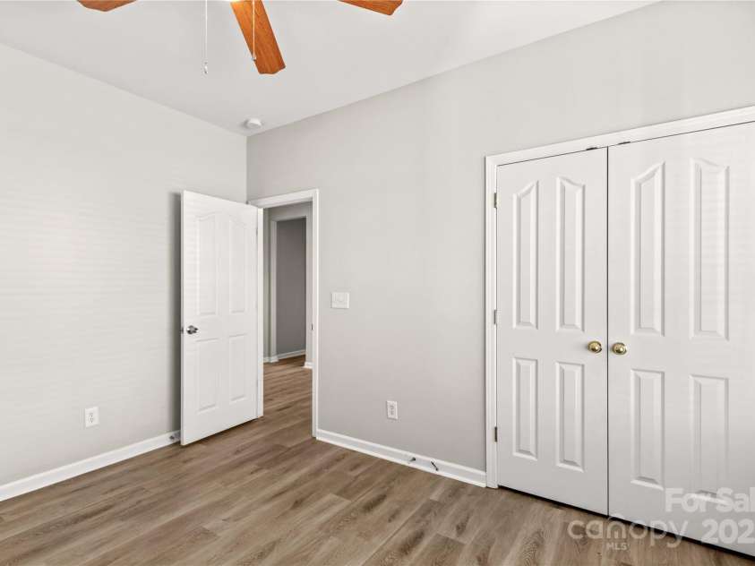124 Zolder Lane, Mooresville, NC 28117.  MLS# CAR4213674, YatesRealty ID 6019. Front Bedroom #2 with ceiling fan and LVP flooring