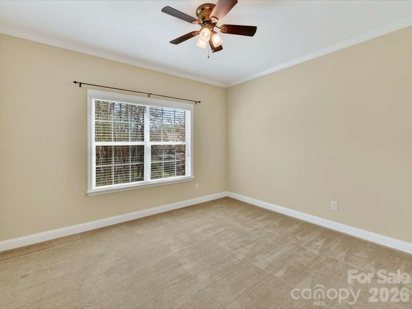 21277 Summerbrook Drive, Cornelius, NC 28031.  MLS# CAR4355875, YatesRealty ID 6062. Second bedroom on main level with large windows and crown molding