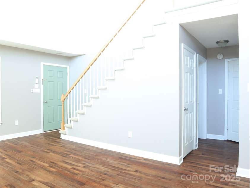 672/715 Windswept Ridge Road, Canton, NC 28716.  MLS# CAR4229345, YatesRealty ID 6077. House #2 - Hall leading to 1/2 bath, laundry, and master bedroom.  The stairs lead to the second bedroom with private ensuite.
