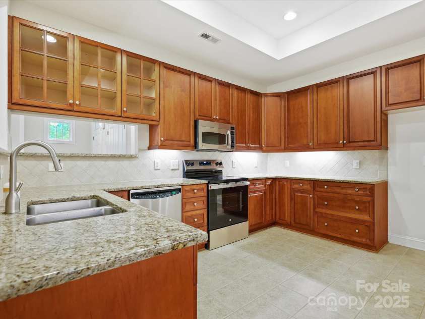 1910 Mezzo Court, Matthews, NC 28105.  MLS# CAR4245911, YatesRealty ID 6115. Beautiful upgraded kitchen cabinets, granite counters and tile backsplash