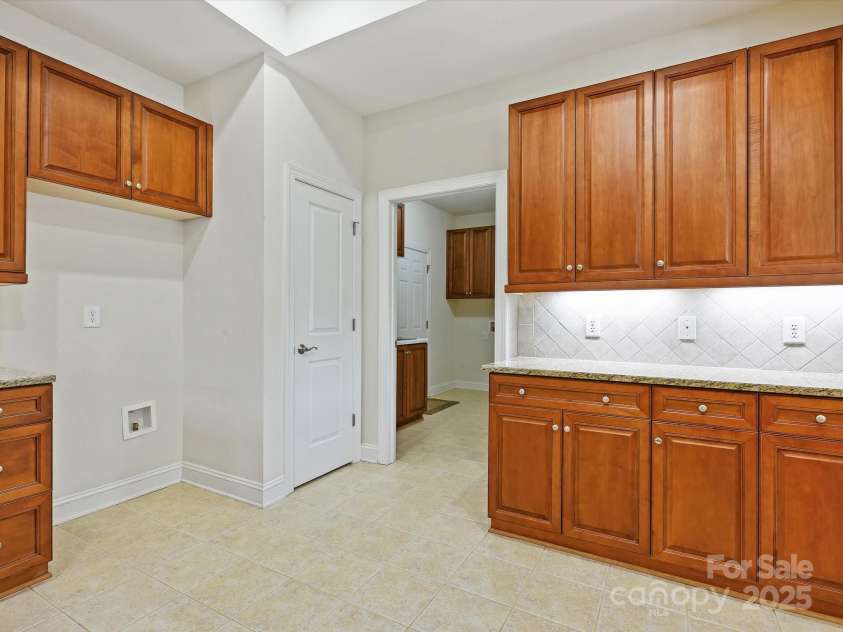 1910 Mezzo Court, Matthews, NC 28105.  MLS# CAR4245911, YatesRealty ID 6115. Kitchen looking at pantry door and entry into full laundry room