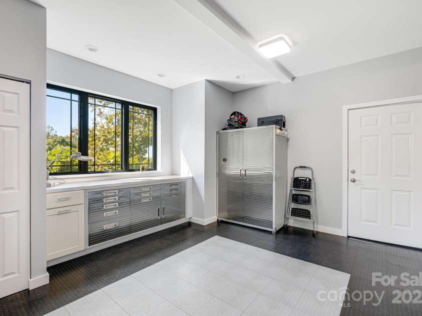 1387 Woods Ammons Road, Mars Hill, NC 28754.  MLS# CAR4303363, YatesRealty ID 6175. Workshop and bench off of garage - Cabinet Conveys