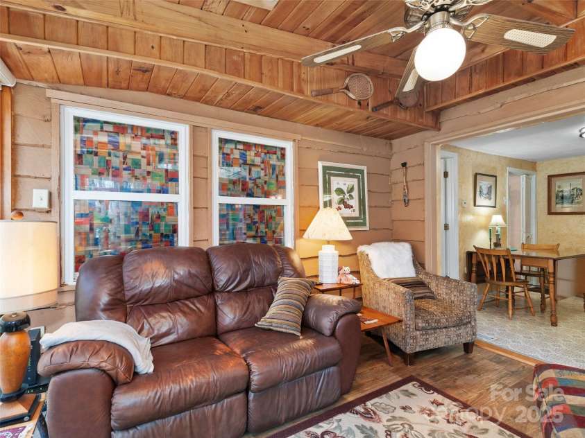 16 Limestone Drive, Franklin, NC 28734.  MLS# CAR4244542, YatesRealty ID 6187. Step into a space that feels like a warm hug—wood-paneled walls, soft natural light, and timeless comfort. Whether you're sipping coffee on a quiet morning or hosting loved ones for a cozy weekend, this home wraps you in 