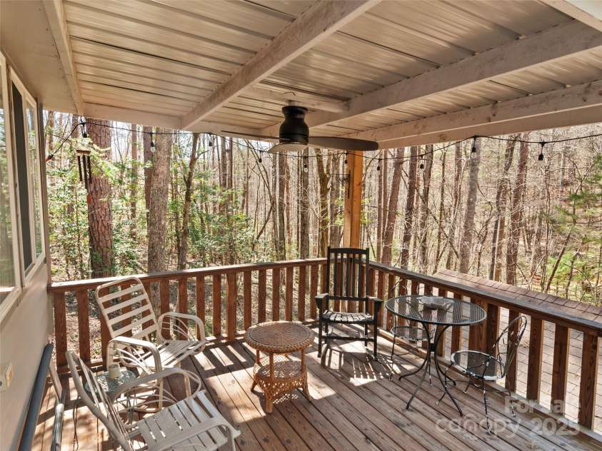 16 Limestone Drive, Franklin, NC 28734.  MLS# CAR4244542, YatesRealty ID 6187. This relaxed, tree-wrapped porch invites you to slow down, sip something warm, and stay awhile—mountain living at its coziest.