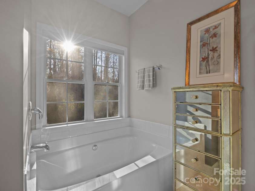 43 Golden Pond Way, Hendersonville, NC 28791.  MLS# CAR4234066, YatesRealty ID 6305. The adjoining primary bath has a soothing soaking tub with a view to the private back yard.