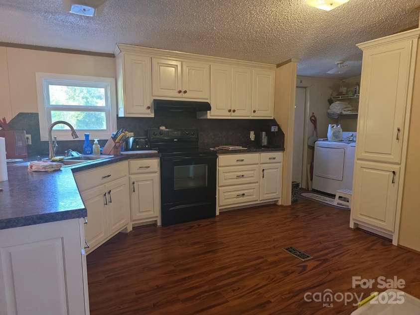 927 Miles Road, Jefferson, SC 29718.  MLS# CAR4247335, YatesRealty ID 6385. Kitchen with upgraded cabinets, looking towards laundry room