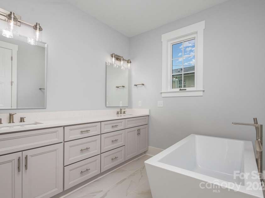 2305 Sanders Avenue, Charlotte, NC 28216.  MLS# CAR4187672, YatesRealty ID 6413. Primary bath elegant vanity & tub
