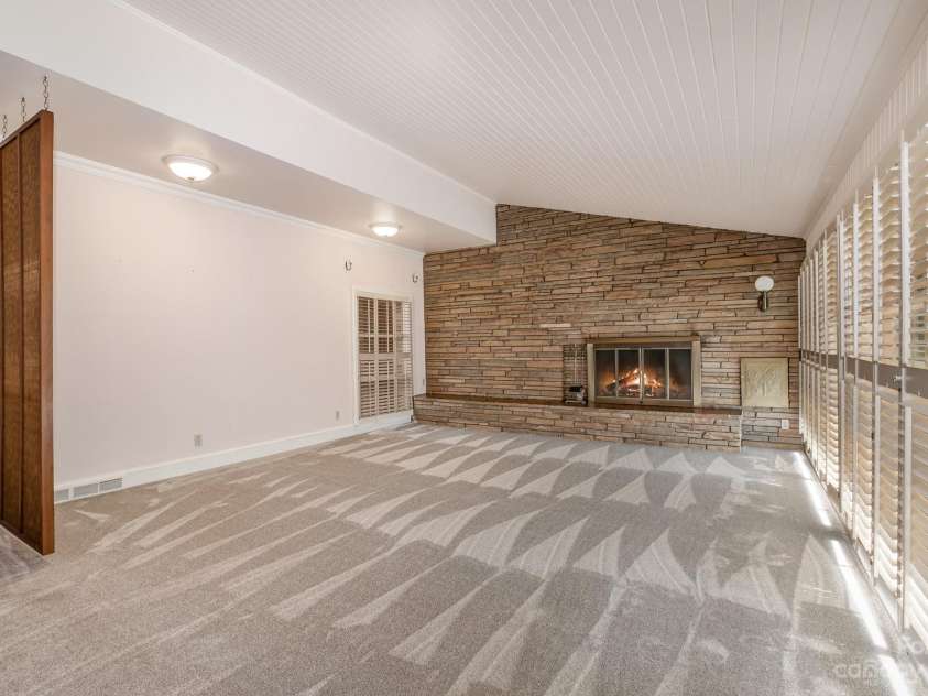 2756 Peachtree Road, Statesville, NC 28625.  MLS# CAR4072282, YatesRealty ID 644. Beautiful room with stone fireplace and a wall of windows for natural light. 