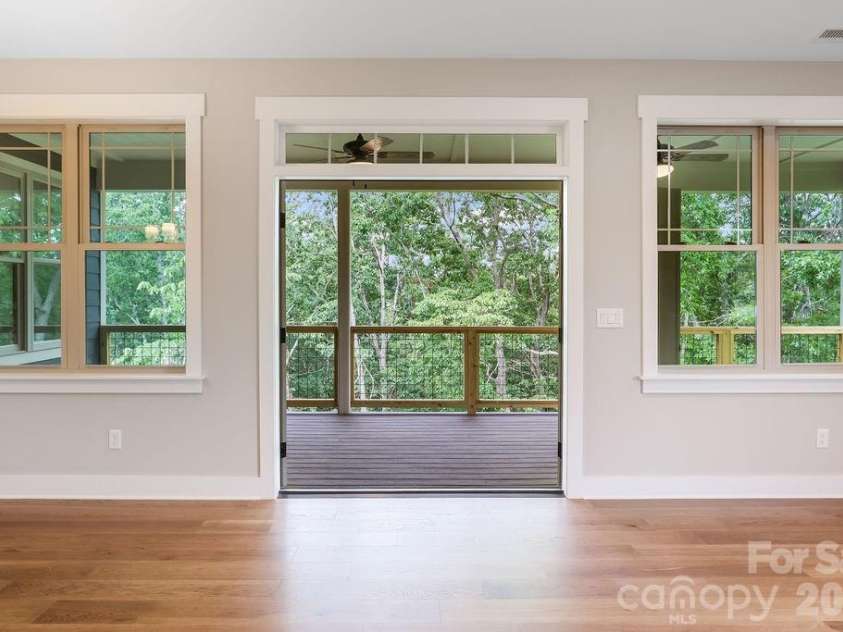 19 Craftsman Overlook Ridge, Arden, NC 28704.  MLS# CAR4342379, YatesRealty ID 6451. French doors open to large, covered Trex deck overlooking private wooded view.