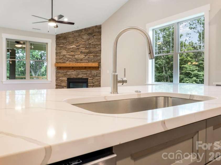 19 Craftsman Overlook Ridge, Arden, NC 28704.  MLS# CAR4342379, YatesRealty ID 6451. Quartz countertop on kitchen island open to great room and French doors overlooking private, wooded view.