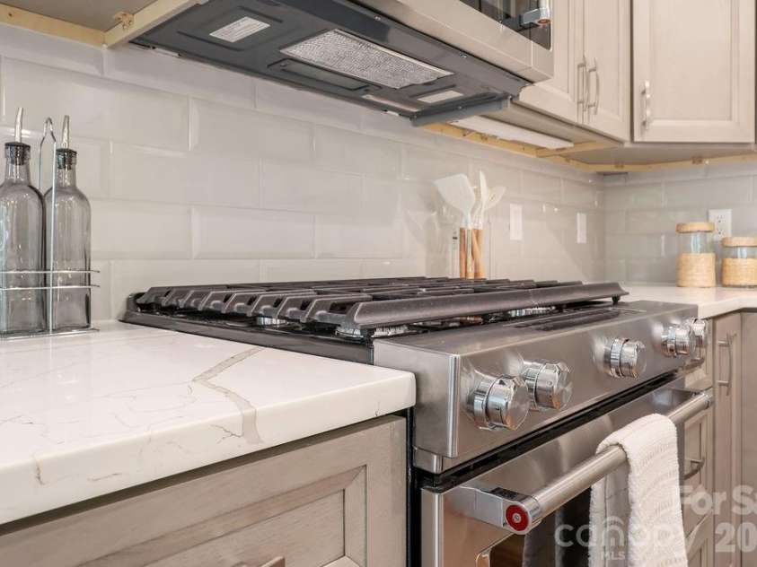 19 Craftsman Overlook Ridge, Arden, NC 28704.  MLS# CAR4342379, YatesRealty ID 6451. Subway tile backsplash, quartz countertops and gas range.