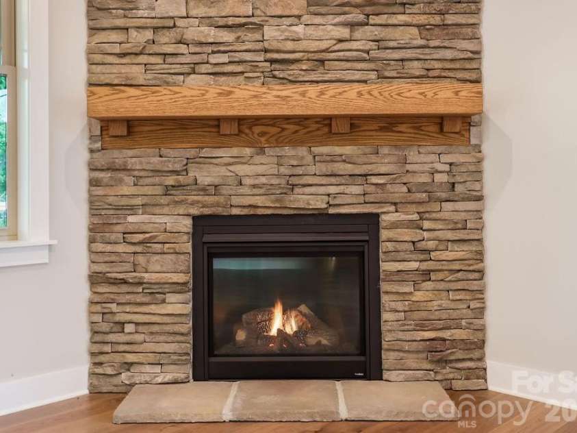 19 Craftsman Overlook Ridge, Arden, NC 28704.  MLS# CAR4342379, YatesRealty ID 6451. Switch controlled gas fireplace with floor to ceiling stone wall.