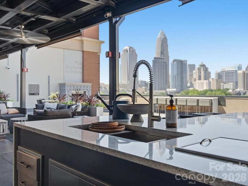 715 Graham Street, Charlotte, NC 28202.  MLS# CAR4383984, YatesRealty ID 6452. Shared rooftop terrace with skyline views, lounge areas, fireplaces, and outdoor kitchen 
