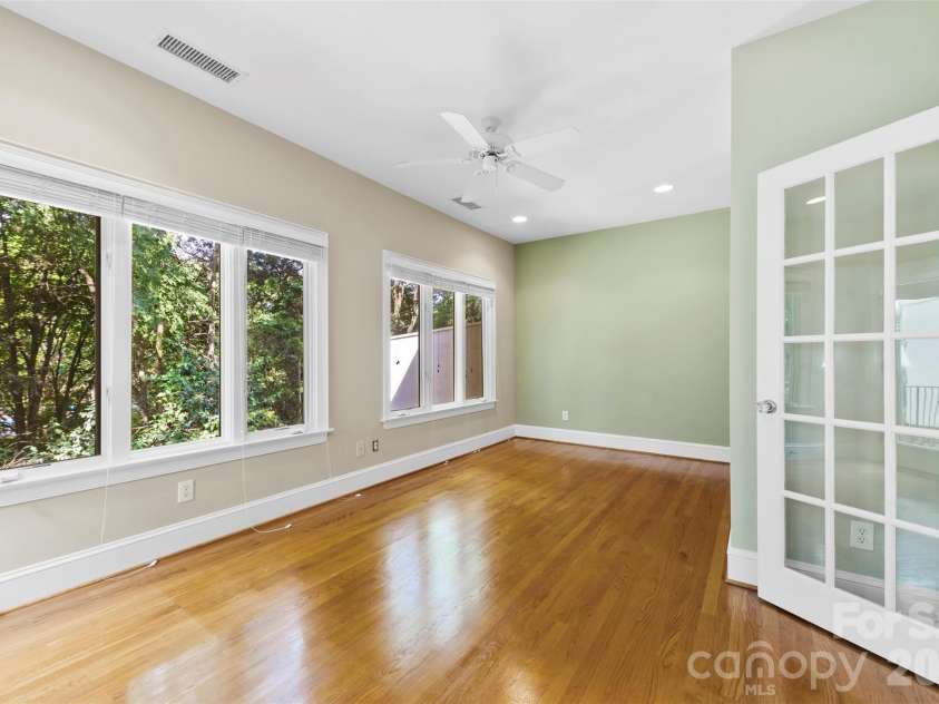 8934 Challis Hill Lane, Charlotte, NC 28226.  MLS# CAR4356123, YatesRealty ID 6483. Sunroom with large windows surrounded by beautiful trees 